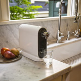 Cypress H630 water filtration system installed on countertop in modern kitchen with farm sink and marble countertop.